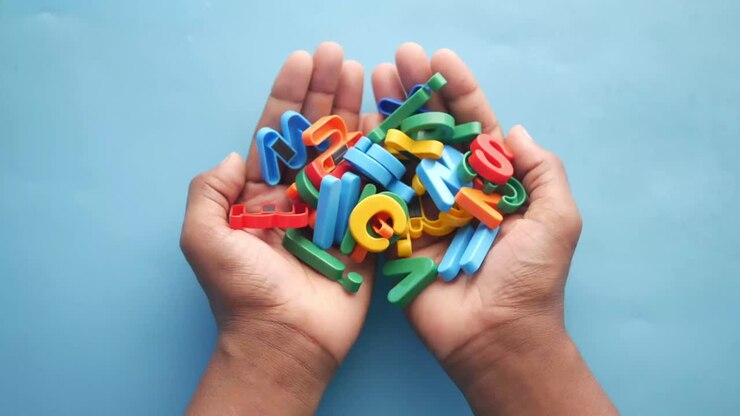 Hands holding colorful magnetic letters