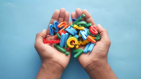 hands holding colorful magnetic letters