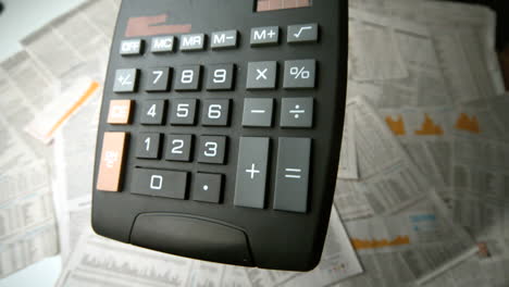 calculadora negra cayendo y rebotando en los papeles