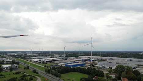 wind turbines generate energy for industrial part of city, aerial view