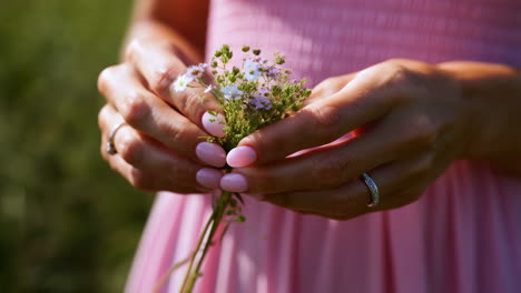close-up of hands holding a delicate bouquet of wildflowers