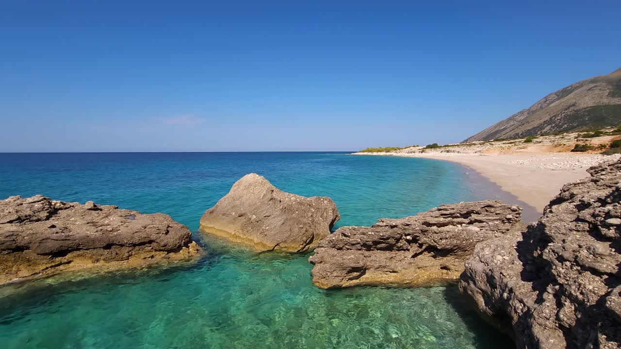 Splendide scogliere sulla costa del Mediterraneo, bagnate dal mare turchese in una laguna poco profonda vicino a una spiaggia tranquilla.
