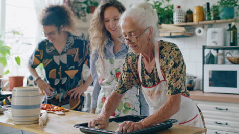 elderly grandmother preparing to bake pizza with grandchildren in kitchen