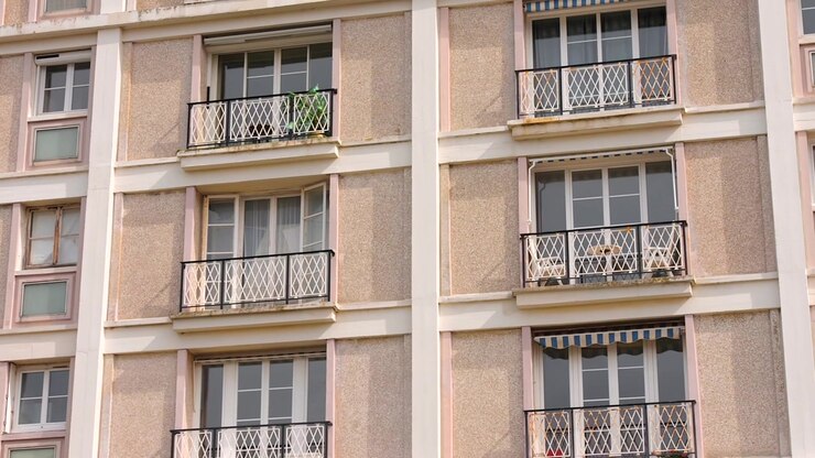 Primo piano di balconi e finestre classici di appartamenti sulla facciata di un edificio alla luce del giorno.