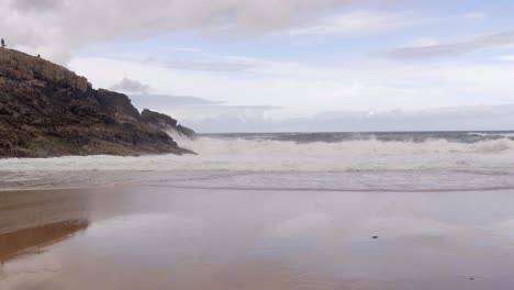 Große-Wellen-Krachen-An-Der-Felsigen-Küste-Und-Am-Sandstrand-Der-Höhleninsel-In-Donegal,-Irland