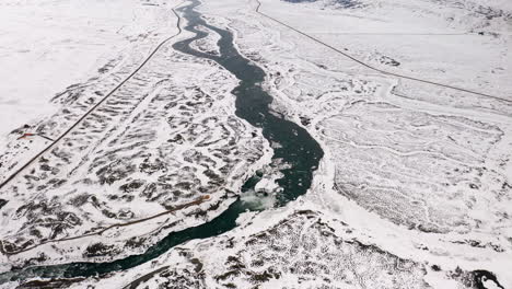 Goðafoss-Waterfall-and-River-Skjálfandafljót-in-North-Iceland-in-Winter,-Aerial-View-of-Famous-Touristic-Destination-Surrounded-by-Vast-White-Snow-Covered-Wild-Lands-and-Trails