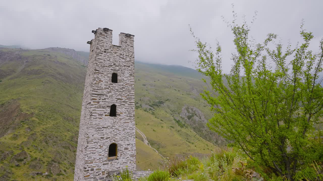 antigua torre de piedra en un paisaje montañoso