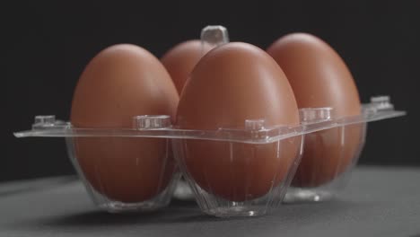 chicken eggs in the cells egg storage box rotating over black background