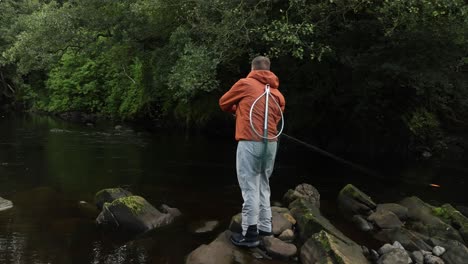 Toma-Manual-De-Un-Pescador-Lanzando-Su-Caña-Giratoria-Mientras-Lleva-Una-Red.