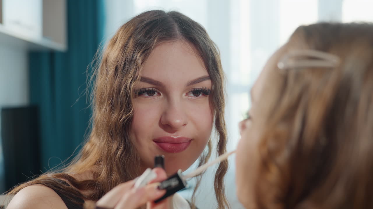 Friend Enjoys Cheerful Makeup Moment, Smiling Woman Put Mascara On Friend During Morning, Casual Morning Setting Showing Woman Applying Mascara To Friend During Lighthearted Shared Moment