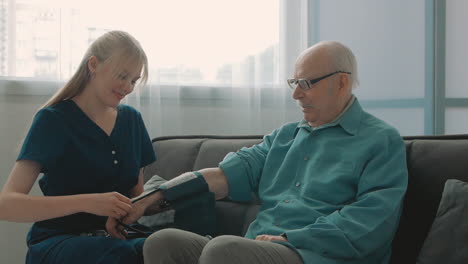 Young-Caring-Nurse-Measuring-Blood-Pressure-And-Heart-Rate-Of-Elderly-Man