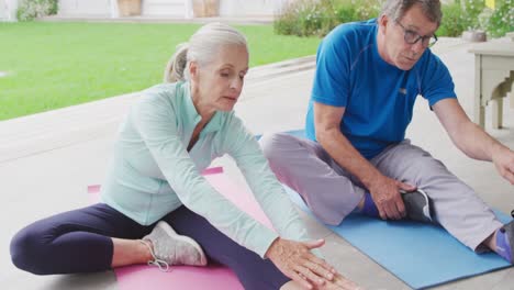 senior couple exercising in a garden