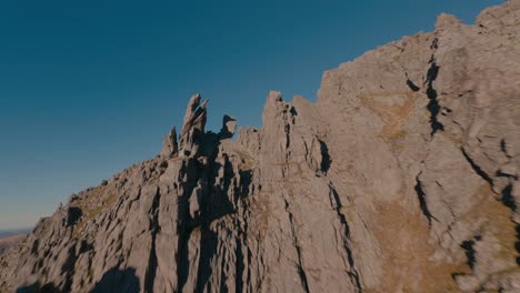 Cinematic-fpv-flight-between-rocky-mountains-against-blue-sky---Molladalen-Mountains,Norway