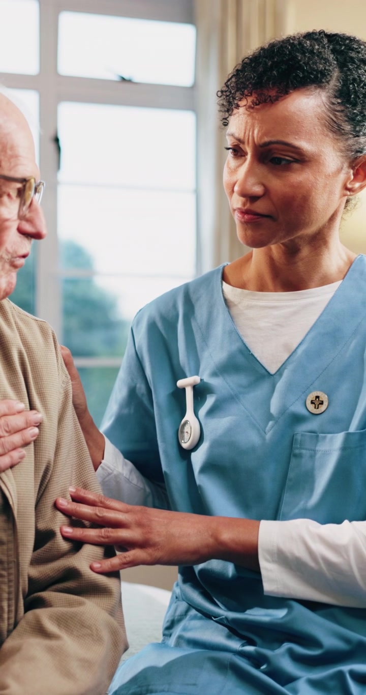 Compassionate Nurse Comforting Elderly Patient in Hospital Room
