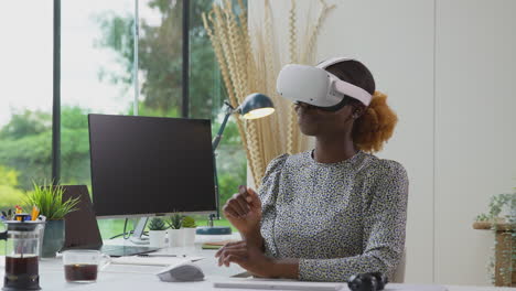 Mujer-Que-Trabaja-Desde-La-Oficina-En-Casa-En-El-Escritorio-Con-Auriculares-Vr-Organizando-Una-Reunión-Virtual-En-Línea