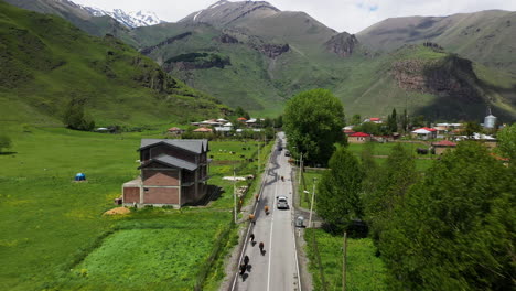 drone shot of a road in juta georgia with cattle on the highway in the caucasus mountains