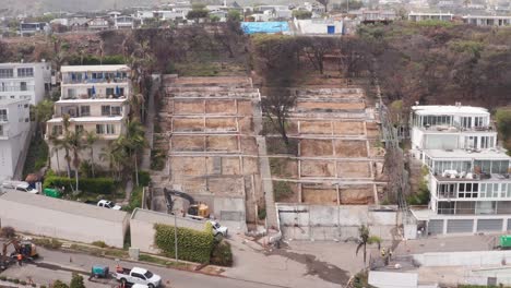 close-up panning aerial shot of burned hillside lots at the oceanfront sunset mesa neighborhood in the aftermath of the palisades fire in malibu, california. 4k