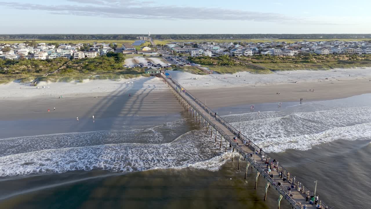 Aerial flight over fishing pier to reveal beachfront homes at sunset beach nc, north caro