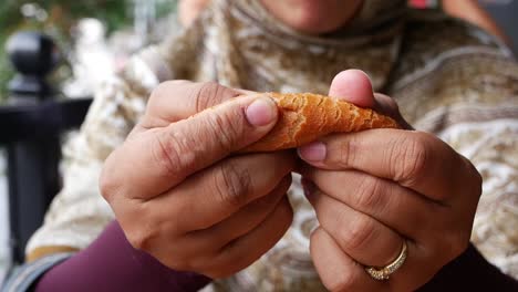 hands breaking a piece of bread