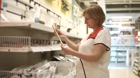 mujer mayor comprando utensilios de cocina en una tienda