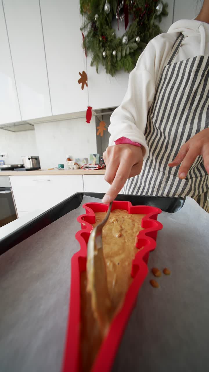 Woman Baking Christmas Tree Cake in Modern Kitchen