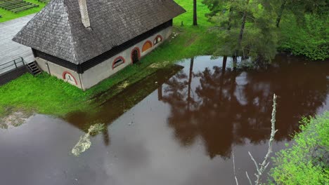 old historic farmhouse near small lake with surroundings reflections