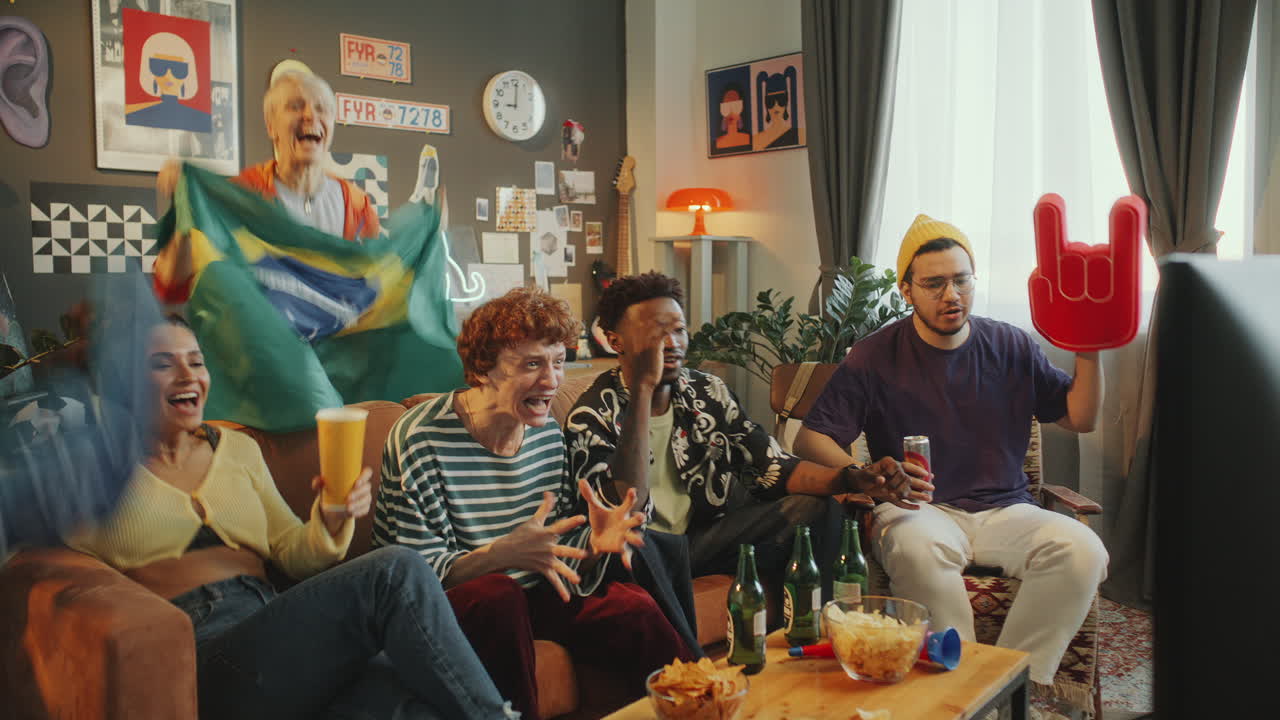 Soccer Fans Watching Game on TV and Celebrating with Brazilian Flag
