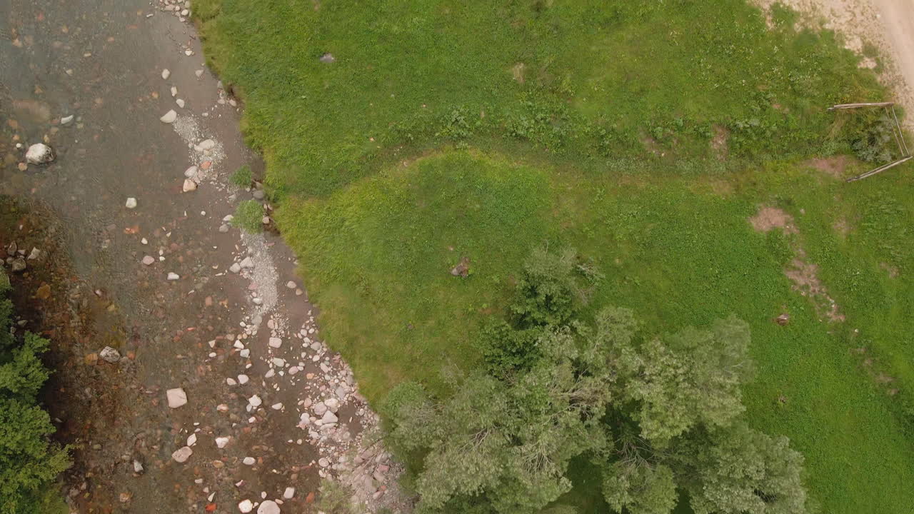 вид сверху на скалистую реку на фоне зеленых лугов и листвы в сельской местности на севере италии