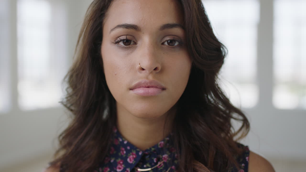 retrato en primer plano de una joven hispana atractiva que parece seria pensativa ante la cámara gira la cabeza confiada mujer piel perfecta