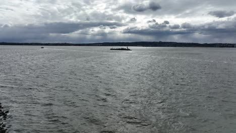 una vista aérea de una barcaza y un ferry navegando en upper bay, nueva york en un día nublado