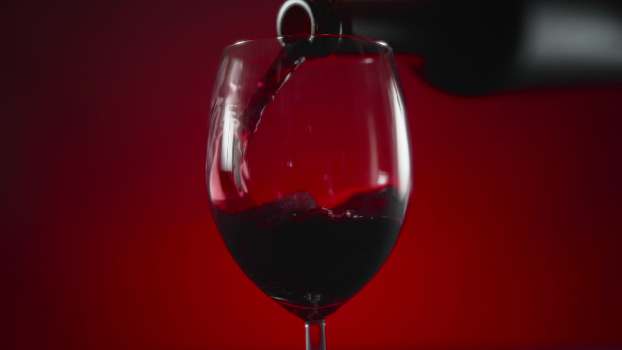 Vino rosso che versa in un bicchiere