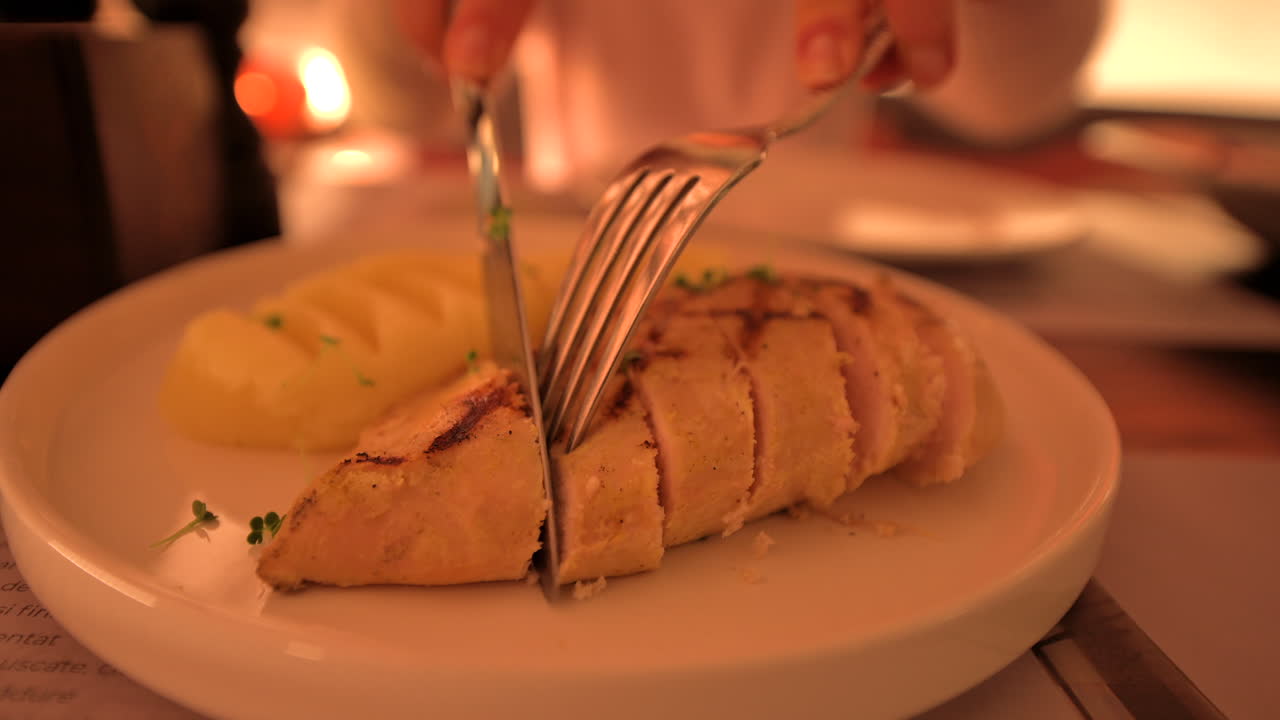 Woman eating chicken fillet at a restaurant at business lunch