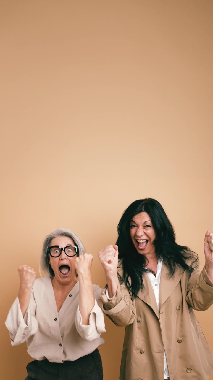 Due donne mature entusiaste che celebrano il successo insieme