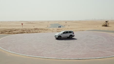 white suv parked in a desert roundabout