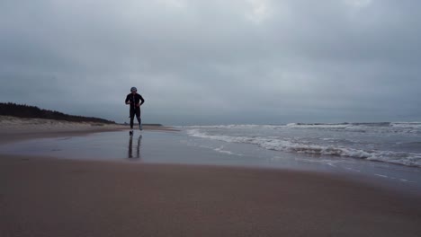 Der-Junge-Mann-Läuft-Am-Strand-Und-Tritt-Ins-Wasser