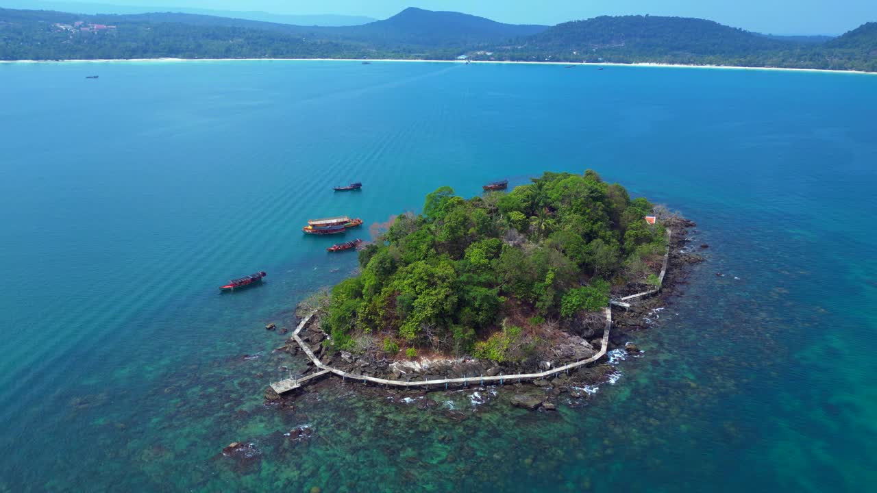 Tourist boats surrounding tropical Koh Toch Island near Sihanoukville, Cambodia. Gorgeous aerial view flight static tripod hovering drone