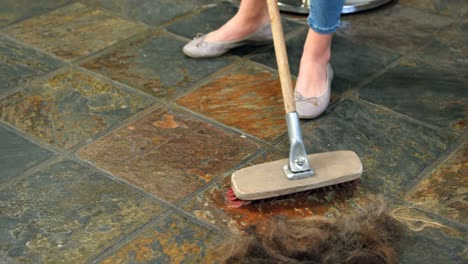 hairdresser cleaning the waste on floor