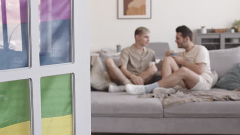 two young men sitting on sofa and talking