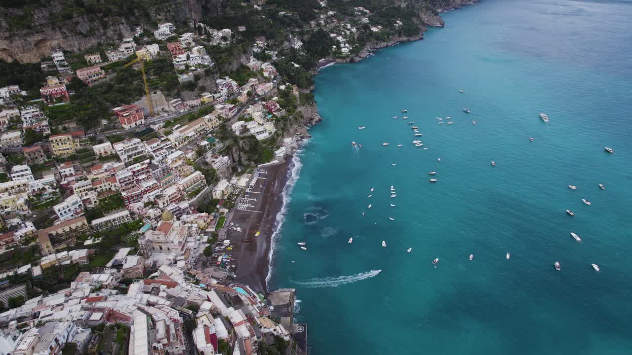 Epica vista a volo d'uccello della spiaggia della città costiera di Positano e dell'oceano blu turchese sulla Costiera Amalfitana in Italia - Aerea.