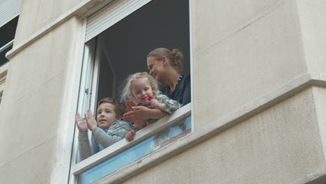 aislamiento de covid-19 mirando hacia afuera por la ventana y aplausos para los médicos