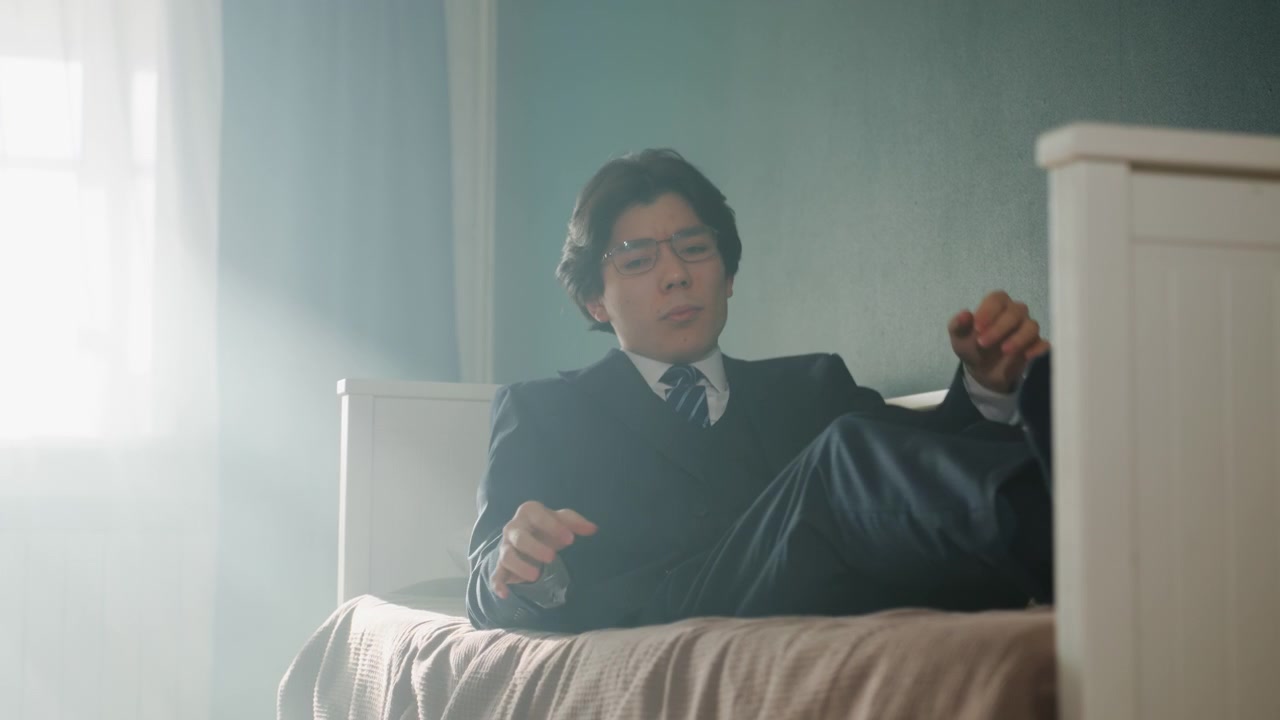 窓からの光の中でベッドに座り、キャンドルを持つ男性。柔らかな光線と霞が部屋を満たし、静かな儀式と内省的なムード。ゆっくりと炎に手を伸ばす動き。ヴィンテージのベッドフレームがある穏やかな朝の雰囲気。