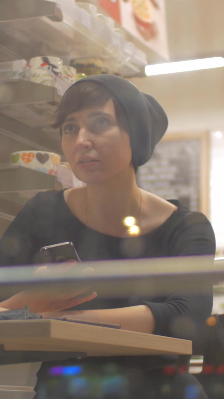 Donna in un caffè che comunica tramite un'app di messaggistica mobile online