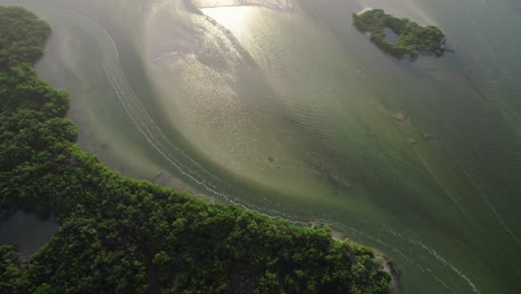 Aerial-over-shallow-beach-waters-at-Holbox,-an-island-in-the-Mexican-state-of-Quintana-Roo,-located-on-the-north-coast-of-the-Yucatán-Peninsula