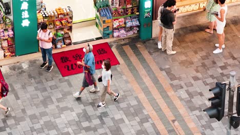 pedestrians stroll past shops in hong kong