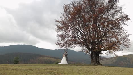 a bride and groom pose together in a mountain landscape