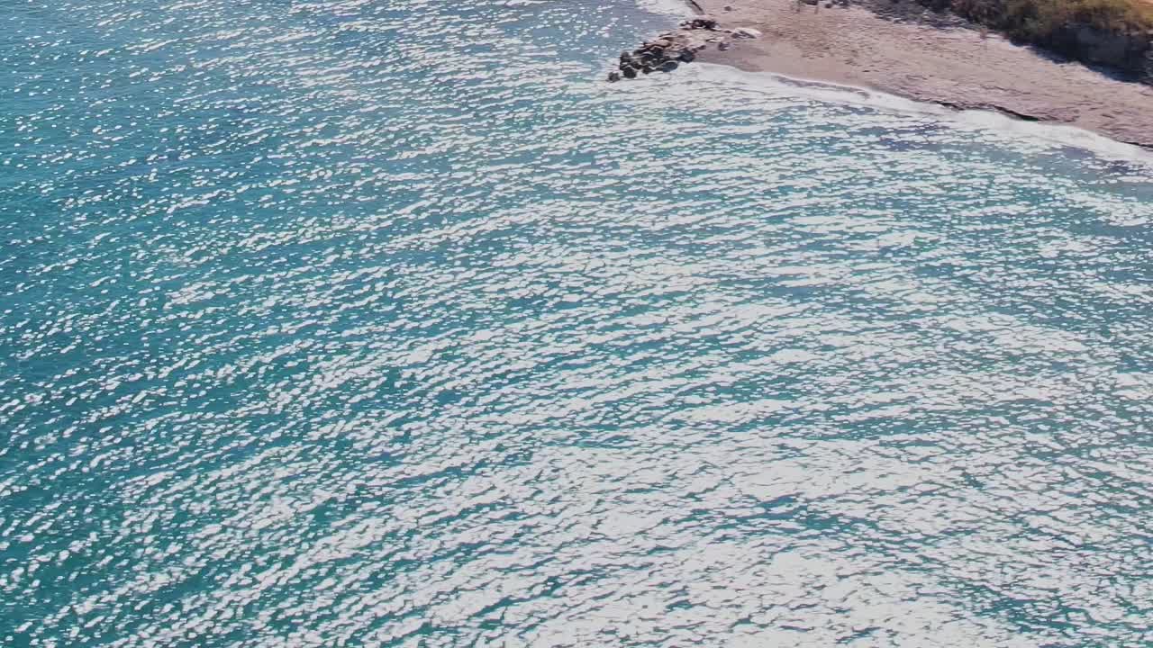 Onde che si infrangono sulla costa di Rodi, in Grecia, durante una giornata di sole