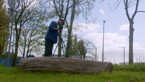 hombre usando una cámara fotográfica analógica de época en amsterdam al aire libre - ancho