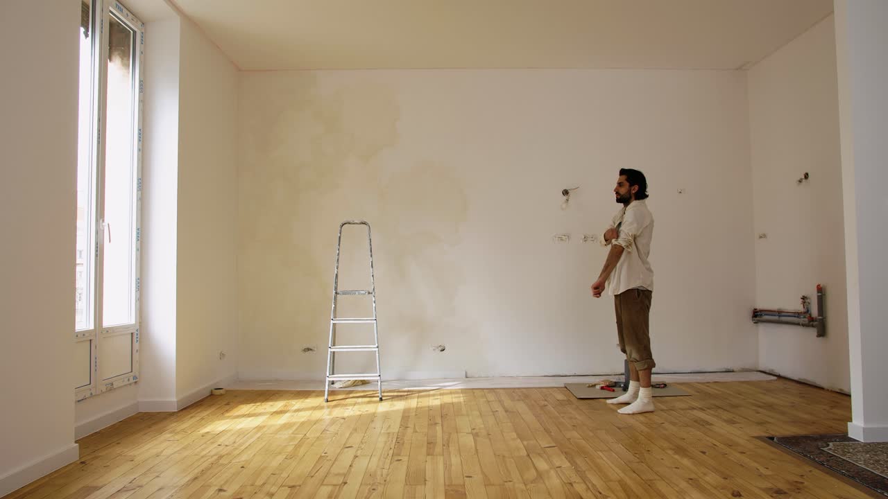 A Man Inside The Empty Room Getting Ready To Paint During Renovation