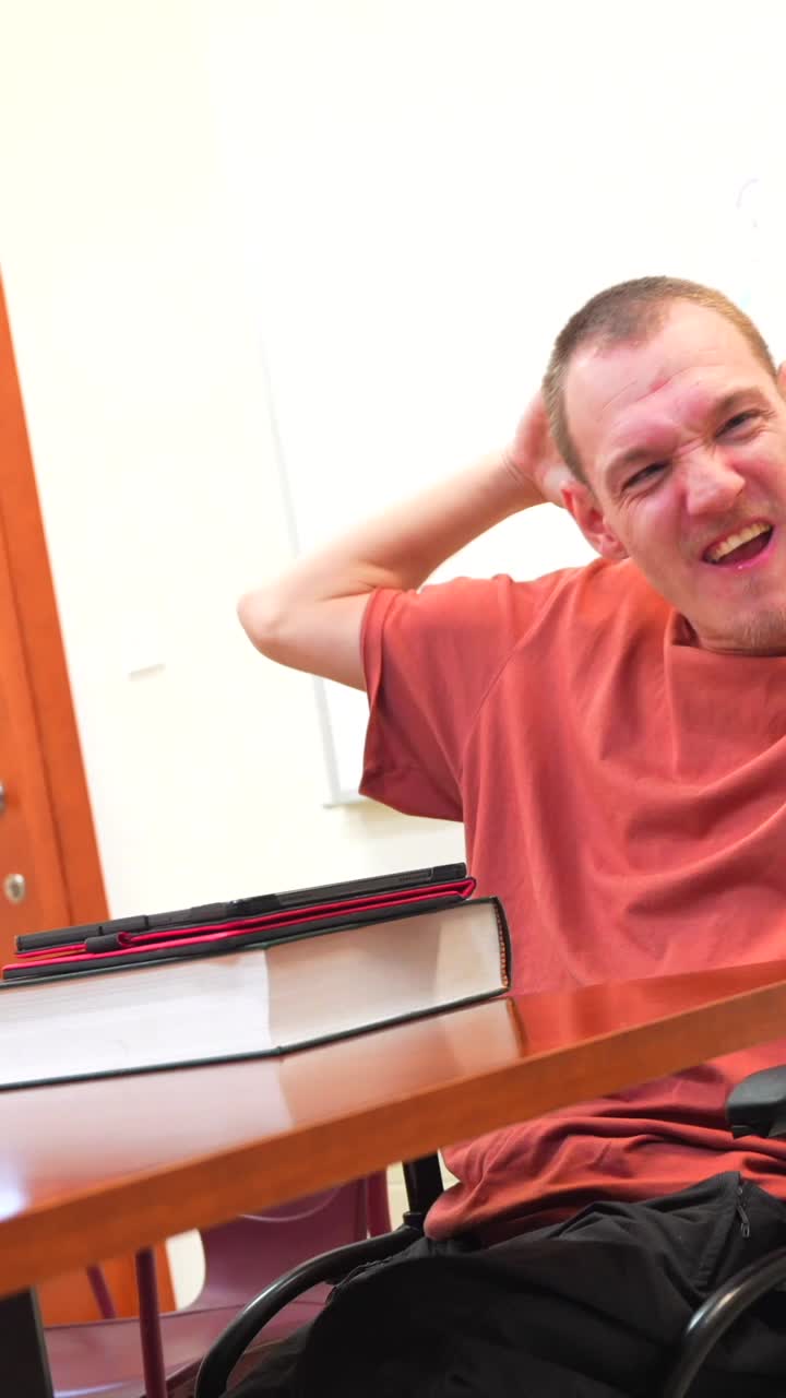 Man in wheelchair celebrating in a classroom
