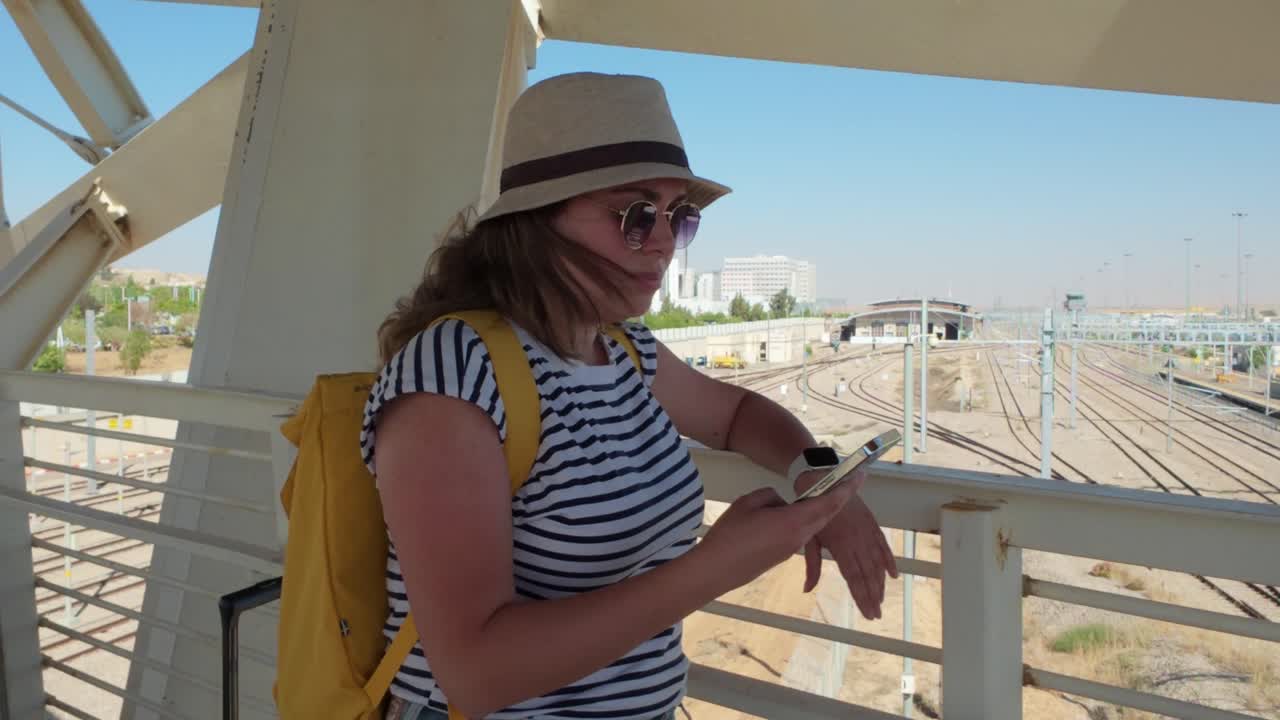 Woman using phone on railway bridge